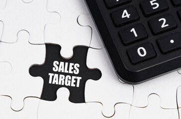 There is a calculator on white puzzles, an inscription in an open cell - SALES TARGET