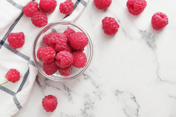 composition of ripe raspberries in a bowl on a textured background