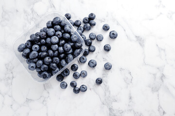 composition of ripe blueberries on a textured marble background
