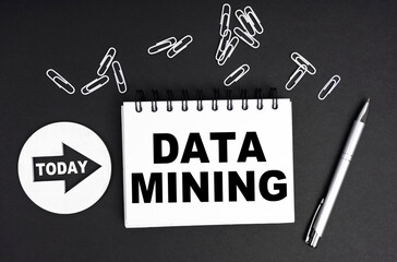 On a black background, a round plate - Today and a notebook with the inscription - DATA MINING