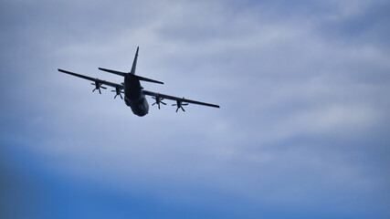 Fototapeta na wymiar Hercules C-130 Transport aircraft banking to starboard in a cloudy sky