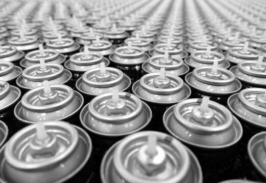 close up of aerosol cans in busy factory