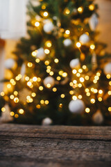 Christmas background. Rustic wood on background of christmas tree  lights golden bokeh. Space for...
