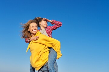 Happy mom and daughter child on seashore, relaxing on sandy beach, autumn winter spring season