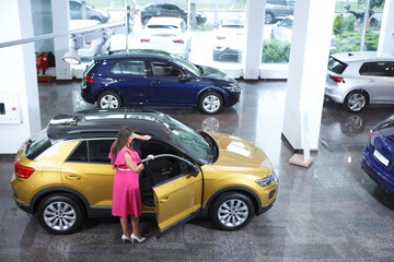 Fototapeta na wymiar Top view shot of a plus size woman choosing new car to buy at auto dealership, copy space