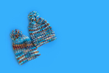 Autumn is coming soon. Stylish fashionable blue knitted hats on a blue background. Minimal fashion. The concept of winter accessories. Advertising purchases. Flat layout, top view, copy space