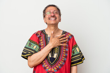 Senior indian man wearing a Indian costume isolated on white background laughs out loudly keeping hand on chest.