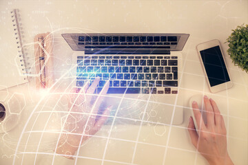 Double exposure of woman hands working on computer and world map hologram drawing. Top View. International business concept.