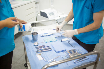 Nurse is preparing dental equipment and tools for a surgery in a dentist office.