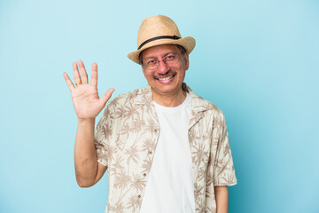 Senior indian man wearing summer clothes isolated on blue background Senior indian woman wearing a african costume isolated on white background smiling cheerful showing number five with fingers.