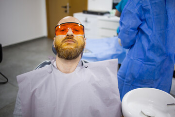 Caucasian male is waiting for a wisdom tooth extraction surgery in a dental chair in a hospital