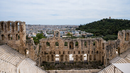Fototapeta premium Remains of The Odeon of Herodes Atticus in Athens. Cityscape of Athens at cloudy day. Acropolis hill.