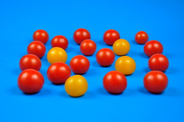 Yellow and red cherry tomatoes. Blue background