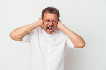 Middle aged indian man isolated on white background covering ears with hands trying not to hear too loud sound.