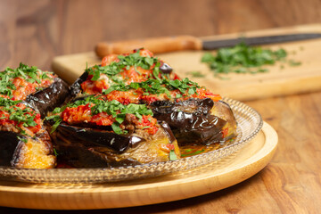 stuffed aubergines with meat topped with tomato and parsley