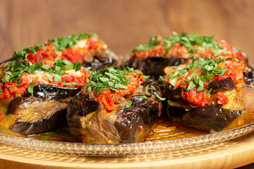 stuffed aubergines with meat topped with tomato and parsley