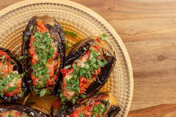 stuffed aubergines with meat topped with tomato and parsley