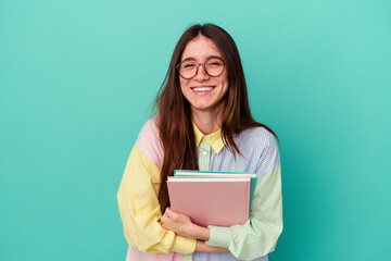 Young student caucasian woman isolated on blue background laughing and having fun.