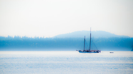 Gaffer Schooner sailboat with sails down on a misty morning