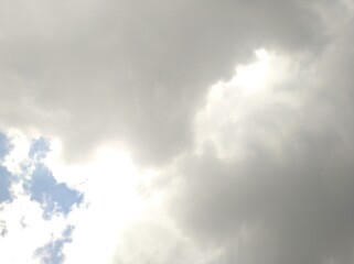 Dark clouds in the blue sky signify rain with sunlight behind it