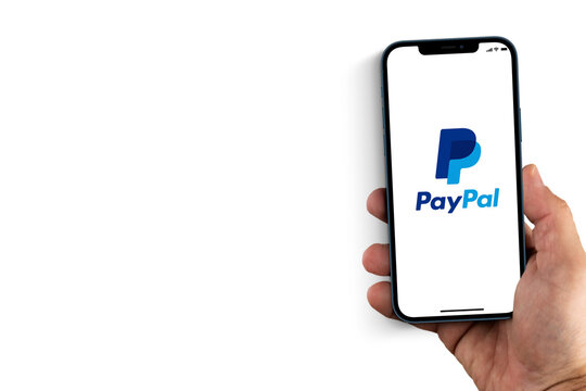 Male hand holding a smartphone with PayPal App on the screen. White background. Rio de Janeiro, RJ, Brazil. August 2021.