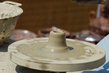 Obraz premium hands of a potter, creating an earthen jar on the circle