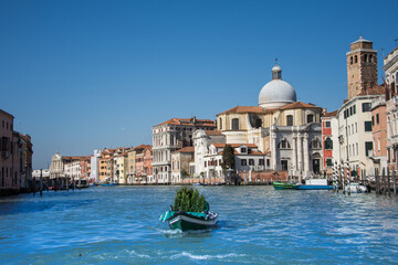 Naklejka premium the boat carries a fir tree on the Grand Canal, Venice, Italy, 2019. march