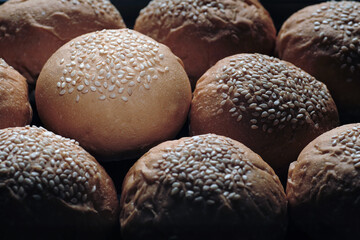 one perfect freshness sesame topping bun in spotlight among others berger breads on oven tray present about concept of picking up  a chosen perfect one