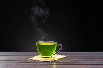 Organic Fresh Green Tea hot green tea placed on wooden table on black background