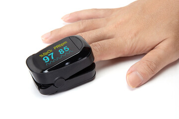 Pulse oximeter on the index finger isolated on a white background.