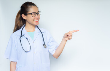 Young happiness Asian healthcare worker in doctor gown pointing to copy space.