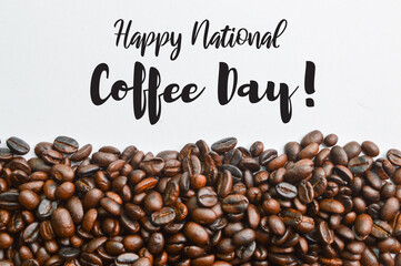 Roasted coffee beans isolated on a white background with text HAPPY NATIONAL COFFEE DAY!