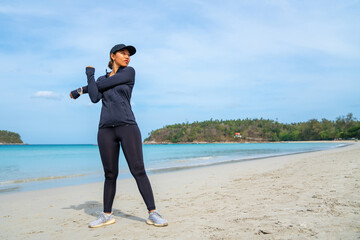 Confidence Asian woman in sportswear do sport training jogging on tropical beach in summer morning. Healthy female athlete workout fitness running on the beach. Outdoor activity lifestyle concept.
