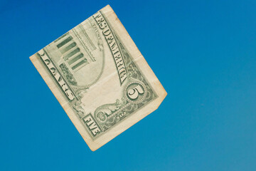 five american dollars on a blue background