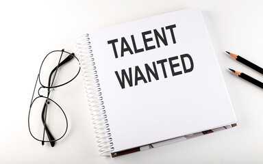 Notepad with text TALENT WANTED . White background. Business concept