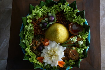 Cone-shaped yellow rice is an Indonesian traditional food, called Nasi Tumapeng. A lively Indonesian rice dish with side dishes.