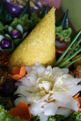 Cone-shaped yellow rice is an Indonesian traditional food, called Nasi Tumapeng. A lively Indonesian rice dish with side dishes.