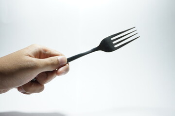 a hand holding a fork, on a white background