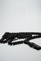 a tasbih that has a black color commonly used by Muslims, on a white background