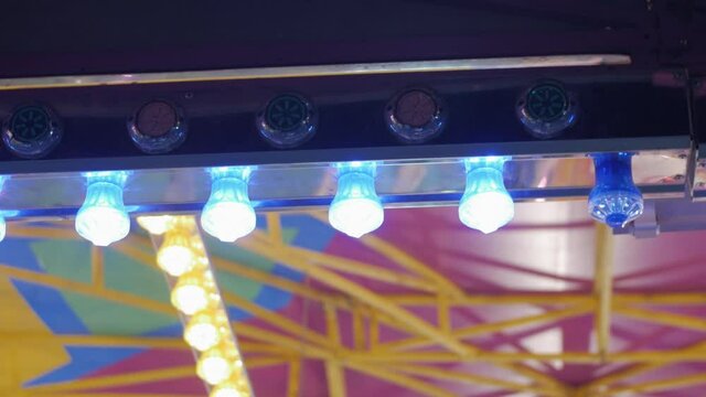 Close up shot of Colorful glowing and blinking festival lights in amusement park