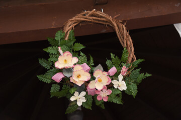 pink faux floral wreath with greenery hanging