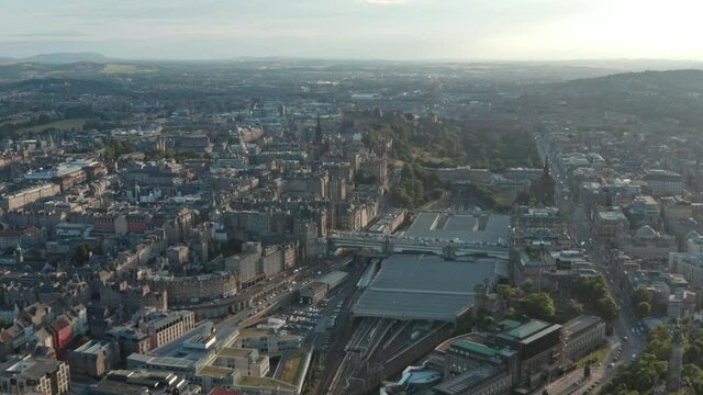 Slow dolly forward drone shot over Waverly towards Edinburgh castle