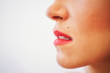 Detail of a woman's lips with red lipstick over white background. Beauty concept