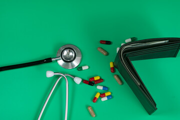 Medical and business concept. Layout of stethoscope, pills and wallet with cash reference to medical bills. Selective focus points
