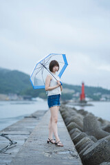 Fototapeta na wymiar 雨の日の海にいる女性