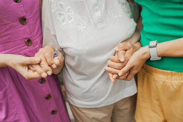 hands of women of different ages hold tightly to each other. old wrinkled female hands. strong family ties. power of women. selective focus