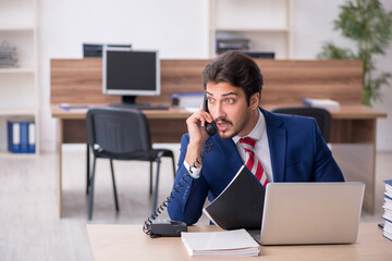 Fototapeta premium Young male employee working in the office