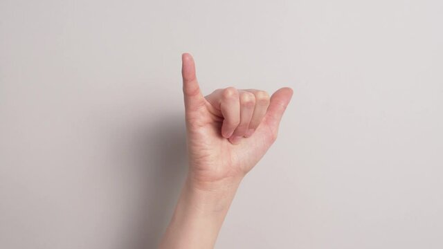 Caucasian Deaf Human Hand Forming Asl Y At White Background. - Closeup Shot