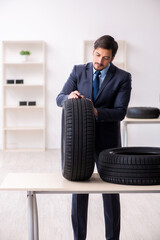 Young man selling tires in the office