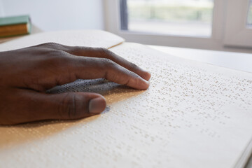 Close up of African-American hand reading braille book for blind, copy space - obrazy, fototapety, plakaty